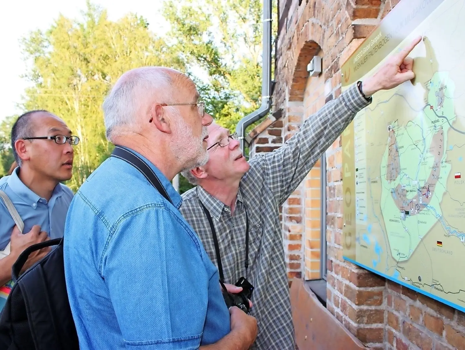 Manfred Kupetz, Vorsitzender des Fördervereins, gibt den beiden Kontrolleuren der Unesco Nire Kagaya aus Japan und Richard Watson aus Irland nochmals einen Überblick auf der Geopark-Karte in Klein Kölzig. ⇥