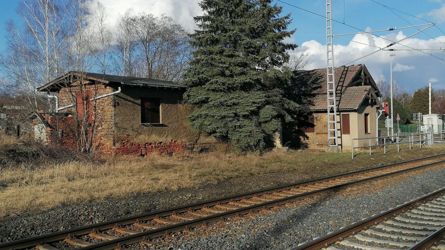 Blick vom gegenüberliegenden Bahnsteig auf das Bahnhofsensemble in Plessa.