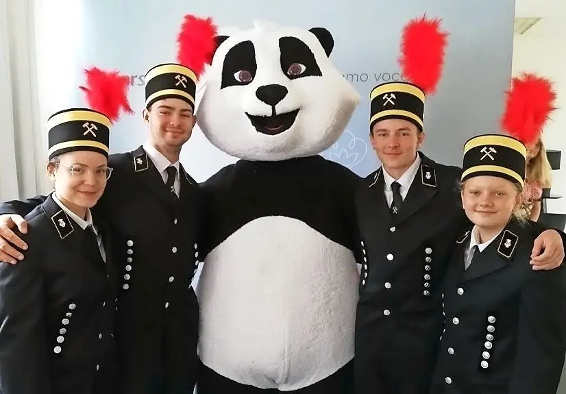 Das Maskottchen der Blumenauer Firma Karsten wird für ein Foto in die Mitte genommen. Farblich passt es sehr gut.
