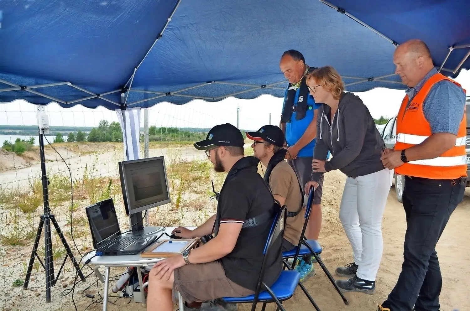 Unter einem Pavillon befindet sich die „Schaltzentrale“ des Messprojektes am Altdöberner See. Am Freitag bekamen Philipp Helbig, Holger Lange und Christian Lehmann Besuch von LMBV-Vizepressesprecherin Stefanie Klein und LMBV-Projektmanager Steffen Petrich (v. l.).⇥