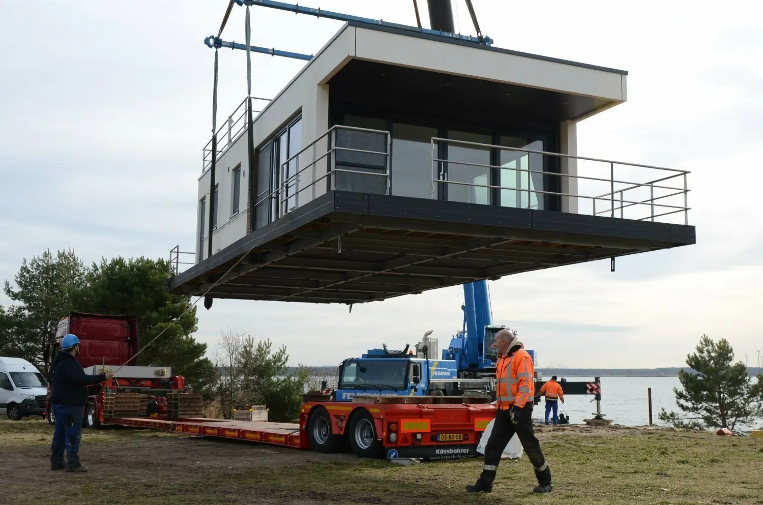 Mit dem Kran sind die jüngsten vier floating houses vom Tieflader zum Ponton gehoben worden. Acht befinden sich bereits jetzt an der Steganlage in Laasow, Ende des Jahres folgen nochmal vier. 2023 werden es dann insgesamt 16 dieser Objekte sein.