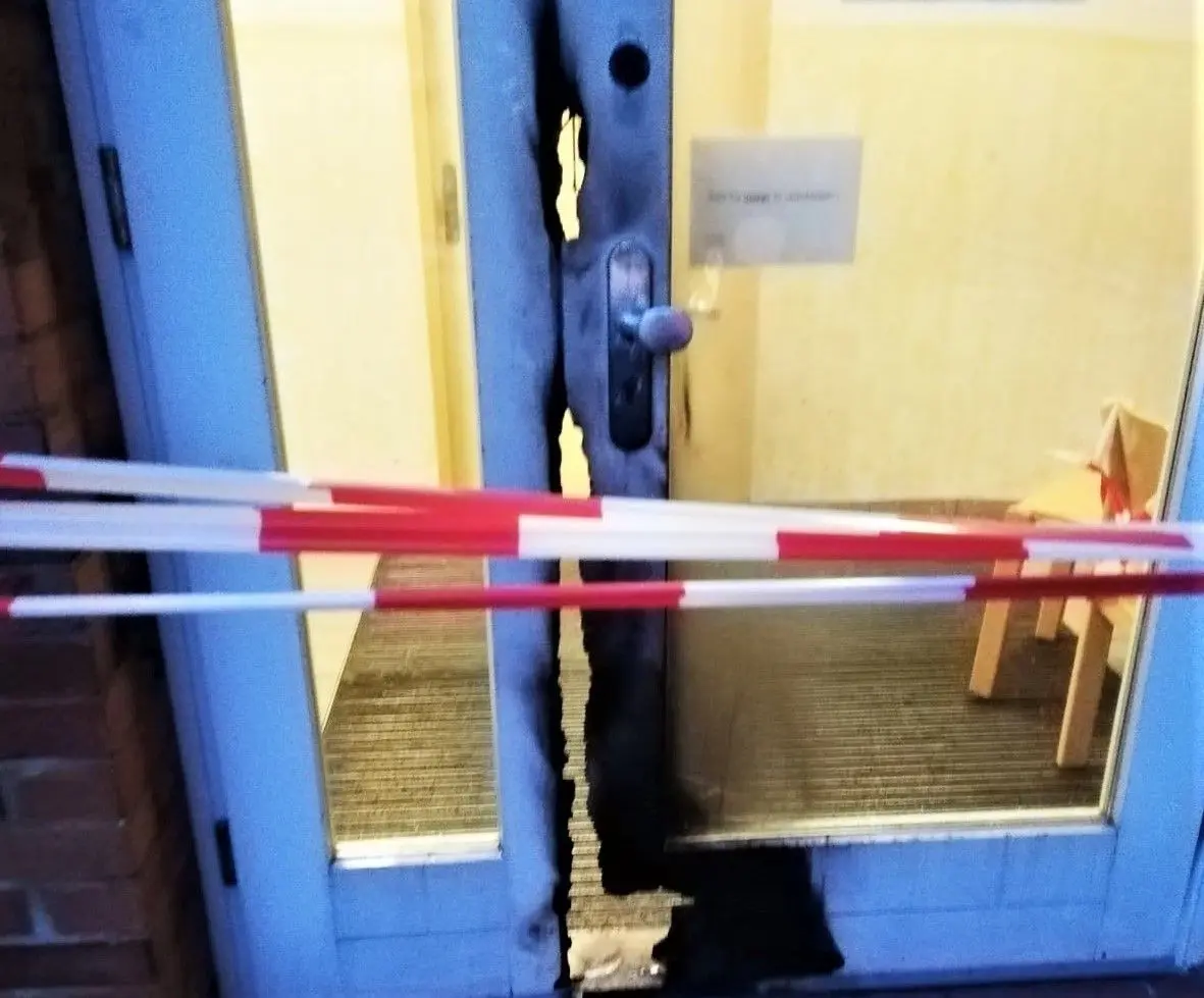 Die Alarmanlage dieser weißen Schultür – im Blaulicht – muss nach dem Vandalismus erneuert werden.