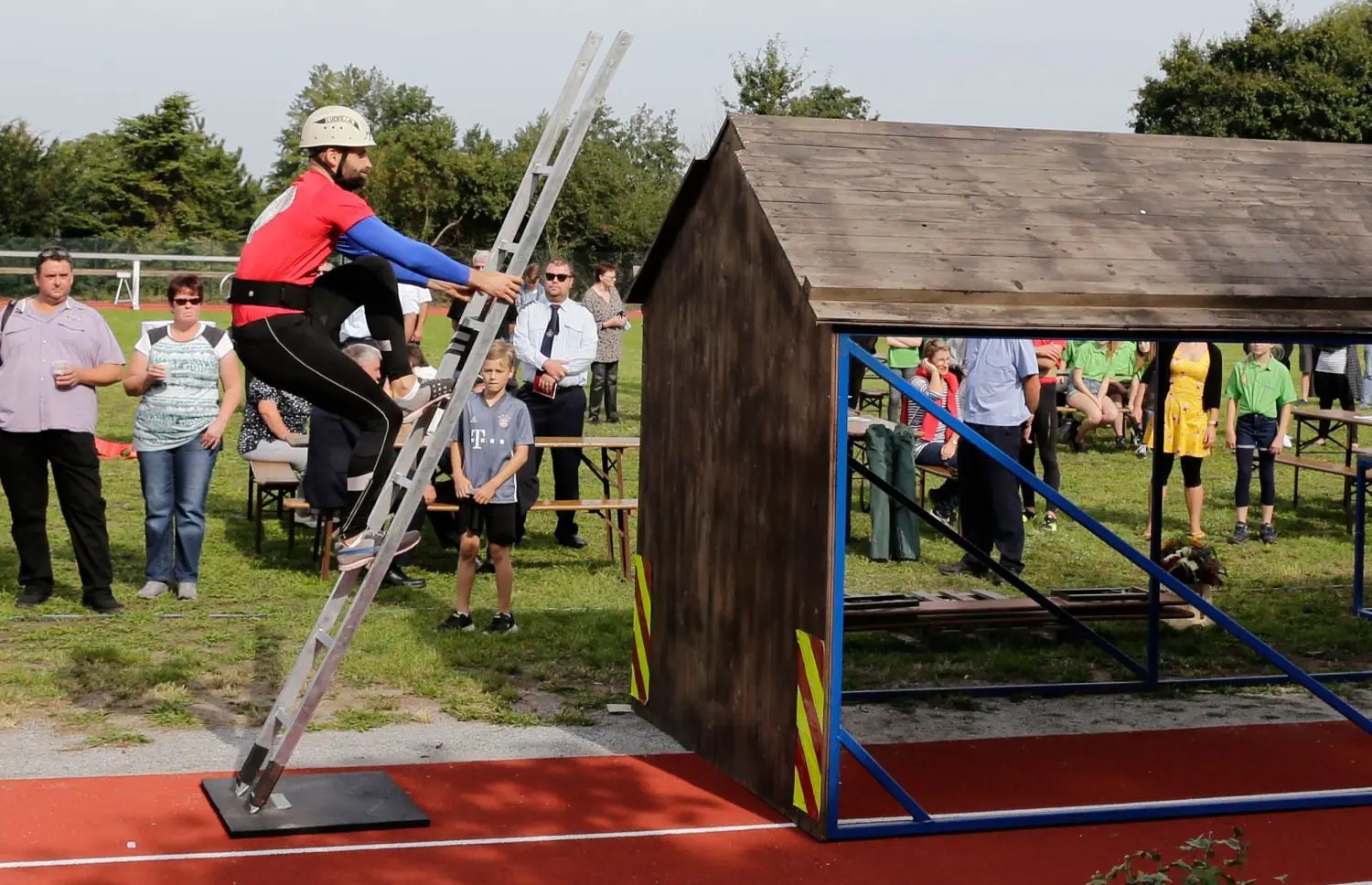 Bei der 4×100 Meter Feuerwehrstafette muss der erste Läufer ein ein 2,5 Meter hohes Haus mithilfe einer Leiter überwinden. René Franzke von der FFW Neuendorf führte es vor.