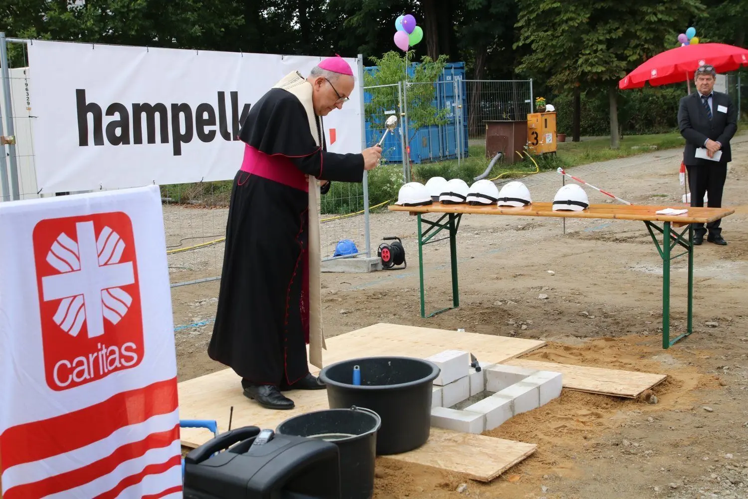 Bischof Wolfgang Ipolt weiht und segnet den Grundstein für die Caritas-Kita.