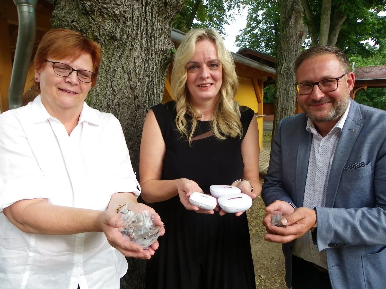 Angelika Mertsch (M.) überreichte den Gubener Rotary-Club-Mitglieder Cornelia Müller und André Schurmann insgesamt 3700 Hörgeräte für die Spendenaktion.
