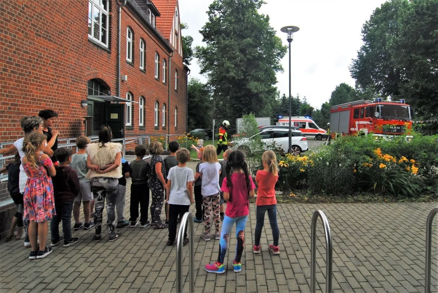 Die Vorschulkinder verfolgen neugierig den inszenierten Einsatz der Rettungskräfte und lernen dabei auch, wie sie sich im Notfall zu verhalten haben.