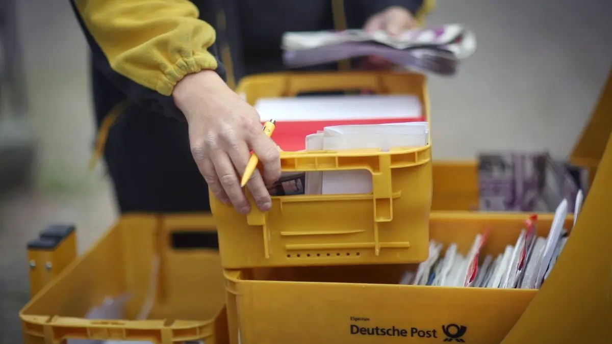 Ein Mitarbeiter der Deutschen Post entnimmt am 09.06.2015 in Idstein (Hessen) Briefe aus seinem Briefzustellerwagen. Die Gewerkschaft Verdi hat ihren unbefristeten Streik bei der Deutschen Post am 09.06.2015 fortgesetzt. Foto: Fredrik von Erichsen/dpa ++ +++ dpa-Bildfunk +++