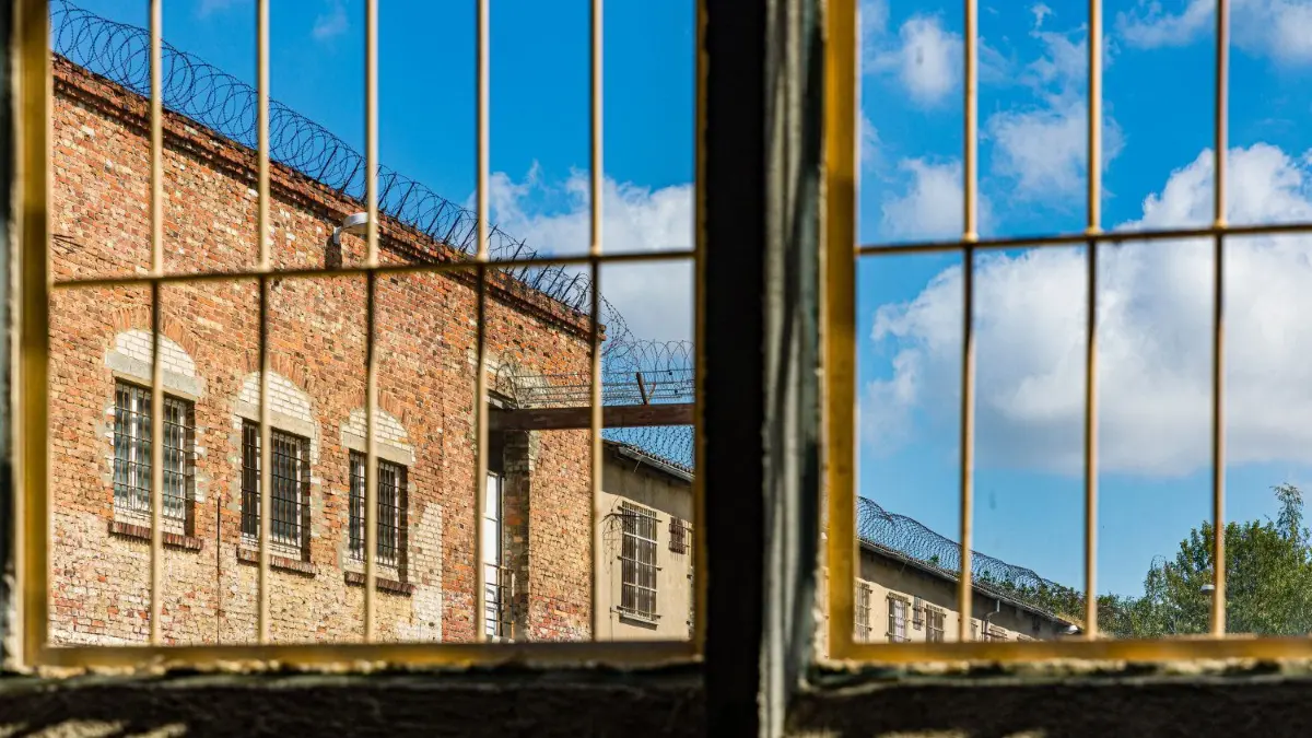 Blick durch ein Fenster in einer Halle in der ehemaligen Strafvollzugsanstalt Cottbus.
26.05.2020, Brandenburg, Cottbus: Blick durch ein Fenster in einer Halle in der ehemaligen Strafvollzugsanstalt Cottbus. Hier unterhielt der VEB Pentacon Dresden eine Fertigungsstätte. Von den (mehrheitlich politischen) Gefangenen wurden Gehäuseteile für Kameras gestanzt und entgratet. Die Produktionsstätte ist ab demnächst nicht mehr begehbar, weil die Deckenkonstruktion gesichert werden muss. Foto: Frank Hammerschmidt