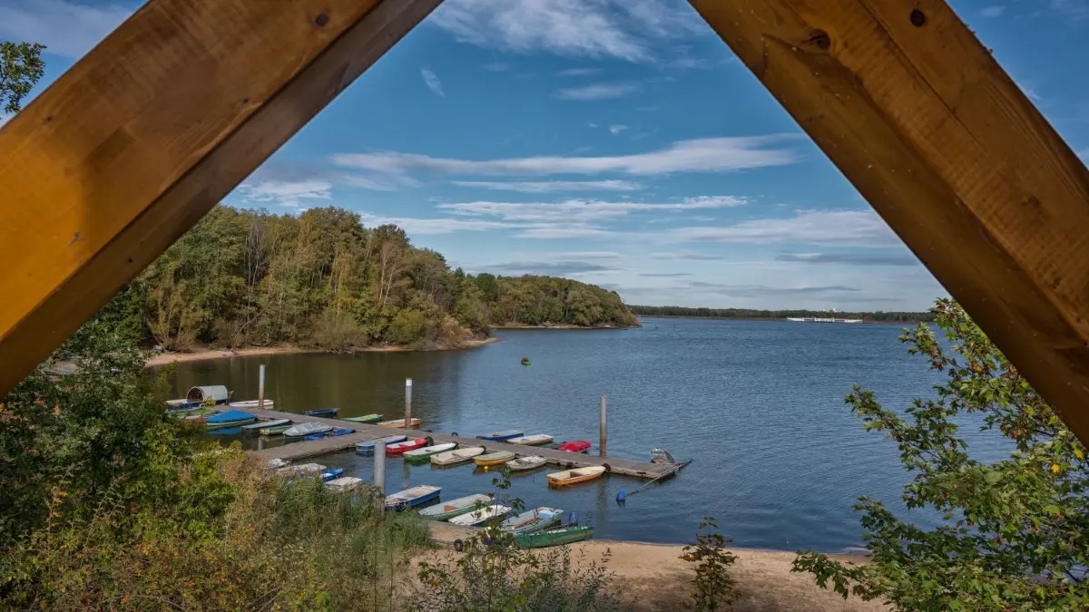 Dichte Wälder, weites Grün, Moore und Gewässer prägen die Landschaft rund um den 960 Hektar großen Spremberger Stausee. Brandenburgs einzige Talsperre ist ein Magnet für alle, die Ruhe und Entspannung mitten in der Natur suchen. Der Stausee liegt in einem Landschaftsschutzgebiet und ist für zahlreiche Vogelarten, u.a. Fischadler und Schwarzstorch, Brut-, Nahrungs- oder Raststätte. Der Stausee lädt zum Baden, Angeln, Segeln und Rudern ein. Für Abwechslung und Spaß sorgen Sport- und Freizeitangebote wie Minigolf, Tischtennis, Fuß- und Volleyball sowie Spielplätze. Großes Spektakel gibt es alljährlich im Juni mit den Wasserfestspielen, bei denen unter anderem ein großes Drachenbootrennen stattfindet. Mit dem (Miet-)Fahrrad, auf Skates oder zu Fuß gibt es rund um die Talsperre jede Menge zu entdecken. Die Talsperre Spremberg wurde zwischen 1958 und 1965 als Aufstauung der Spree erbaut. Der Stausee wird nicht nur als Freizeitgewässer genutzt, sondern dient auch der Regulierung des Wasserhaushaltes der Region. (Quelle: Lausitzer Seenland)
Herbstzeit am Spremberger Stausee.