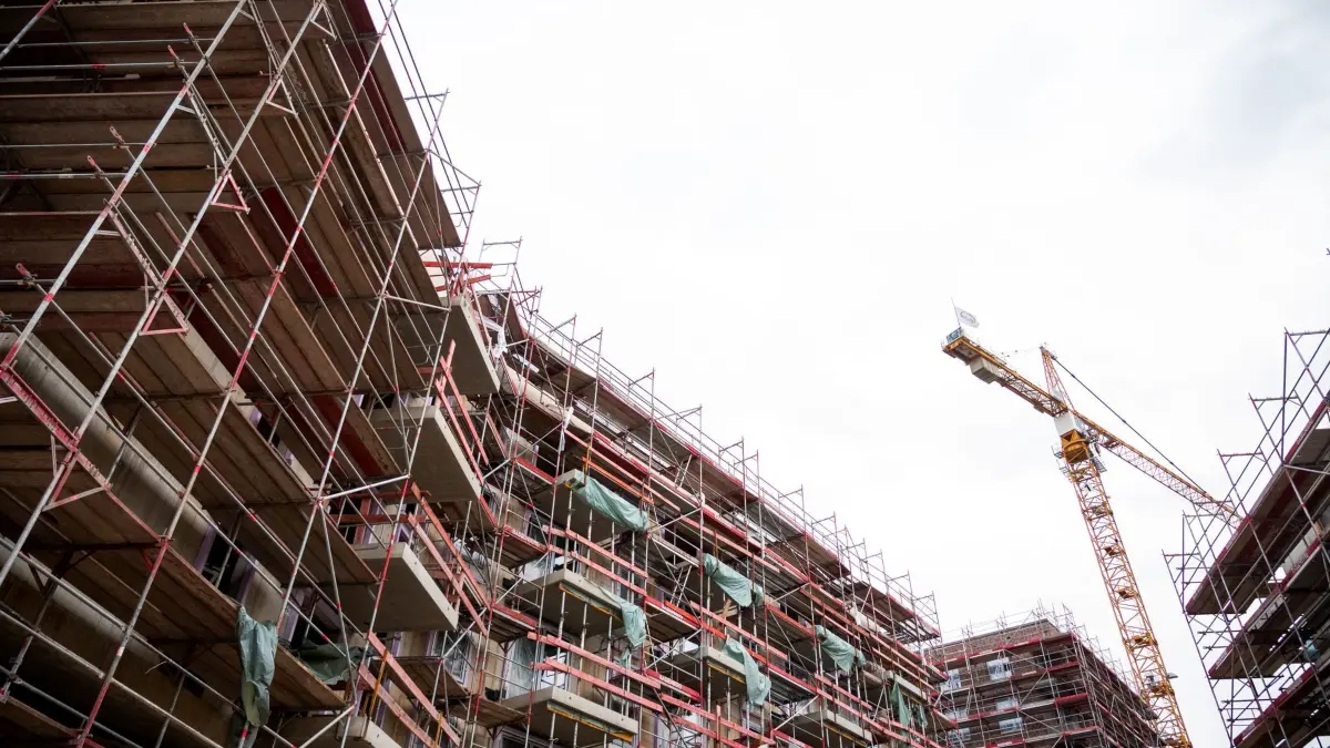 Bauen: 07.04.2024, Hamburg: Ein Kran steht auf einer Baustelle, an der ein Gerüst steht. In der kommenden Woche findet der Wohnungsbau-Tag 2024 unter dem Motto «Konjunktur-Motor Wohnungsbau: Worauf wartet Deutschland?» mit Bundesbauministerin Geywitz und Bundeswirtschaftsminister Habeck statt. Foto: Daniel Bockwoldt/dpa +++ dpa-Bildfunk +++