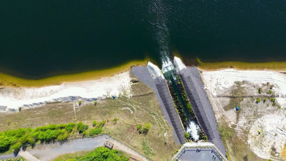 Der Cottbuser Ostsee entsteht: 12.04.2024, Brandenburg, Cottbus: Der Cottbuser Ostsee entsteht im ehemaligen Braunkohletagebau Cottbus-Nord - hier das Flutungsbauwerk (Luftaufnahme mit einer Drohne). Am selben Tag fand eine Pressereise der Stadt Cottbus unter dem Motto «Vorsprung Ost am Beispiel Cottbus - Wie eine Stadt sich wandelt» statt. Eine Station der Pressereise war der entstehende Cottbuser Ostsee. Der See, mit 19 Quadratkilometern, soll einmal das größte künstliche Gewässer Deutschlands werden. Am ehemaligen Tagebau Cottbus-Nord wurde Mitte April 2019 mit der Flutung begonnen. Das Energieunternehmen Lausitz Energie Bergbau AG (Leag) lässt für die Flutung Wasser von der Spree über den Hammergraben in das Tagebauloch fließen. Foto: Patrick Pleul/dpa +++ dpa-Bildfunk +++