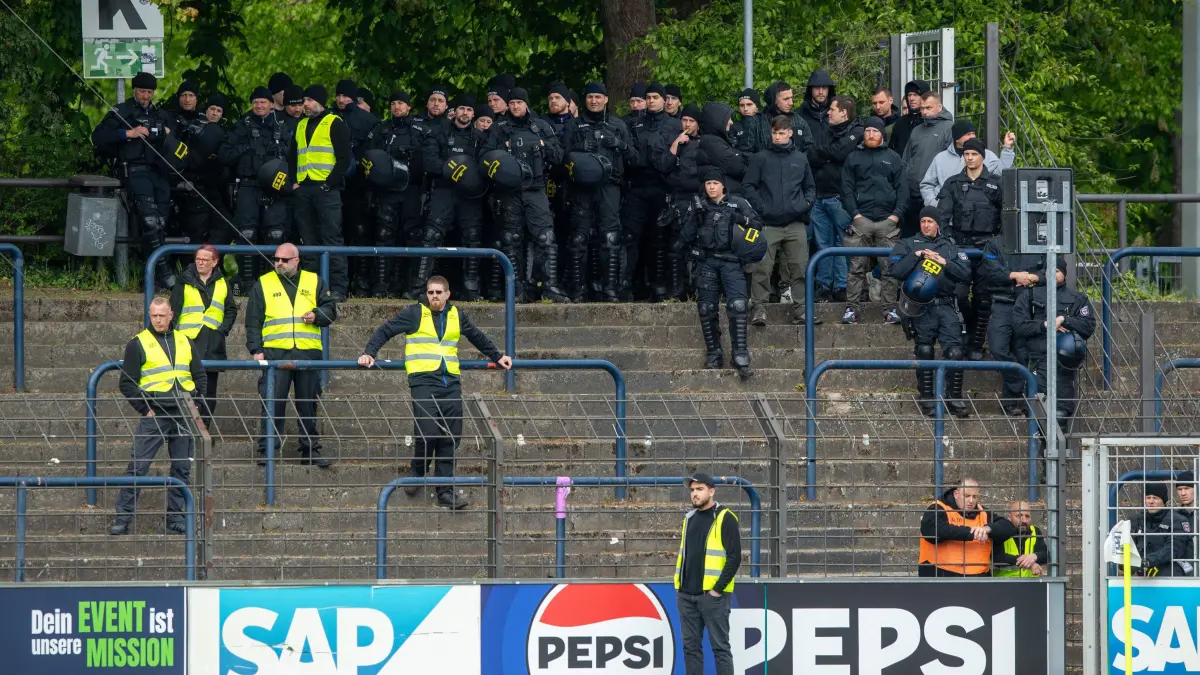 RLNO Babelsberg 03 — Energie Cottbus 2023/24: Fussball, Herren, Saison 2023/2024, Regionalliga Nordost (30. Spieltag), SV Babelsberg 03 - FC Energie Cottbus, Polizisten zwischen den Fans, 21.04. 2024, Foto: Sebastian Räppold / Matthias Koch