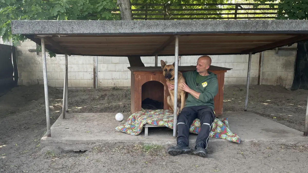 Gemeinsam mit dem Tierpfleger Jürgen Niche sitzt Richard vor seiner Hütte. Mit dem nötigen Abstand und dem Beistand einer vertrauten Person findet Richard auch fremde Menschen vor seinem Zwinger spannend.