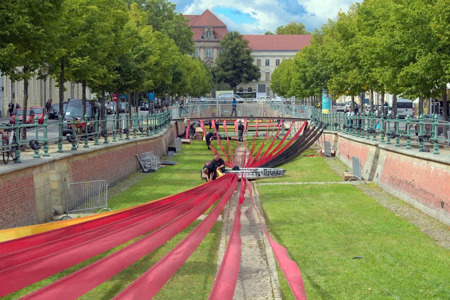 Arbeiter befestigen im Alten Stadtkanal in Potsdam schwarze, rote und gelbe Stoffbahnen. Der Stoff ist Teil der Ausstellung ·Weg zur Einheit·, die wiederum ein Teil der zentralen Feier des 30. Jahrestages der deutschen Einheit in der Landeshauptstadt ist.