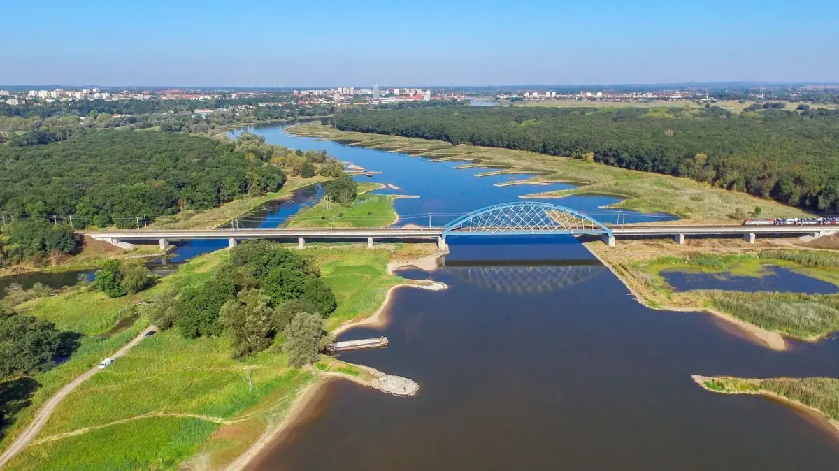Kaum ein Schiff in Sicht: Die Oder — hier südlich von Frankfurt — kann von Schiffen derzeit kaum genutzt werden. Ist die Absicht, daran etwas zu ändern, überhaupt realistisch? Darüber wird seit langem gestritten.
Das Luftbild einer Drohne zeigt den deutsch-polnischen Grenzfluss Fluss Oder südlich von Frankfurt (Oder) (Brandenburg) mit der Eisenbahnbrücke im Vordergrund. (zu dpa «SPD will mit «Rübezahl-Express» für europäische Idee werben») +++ dpa-Bildfunk +++