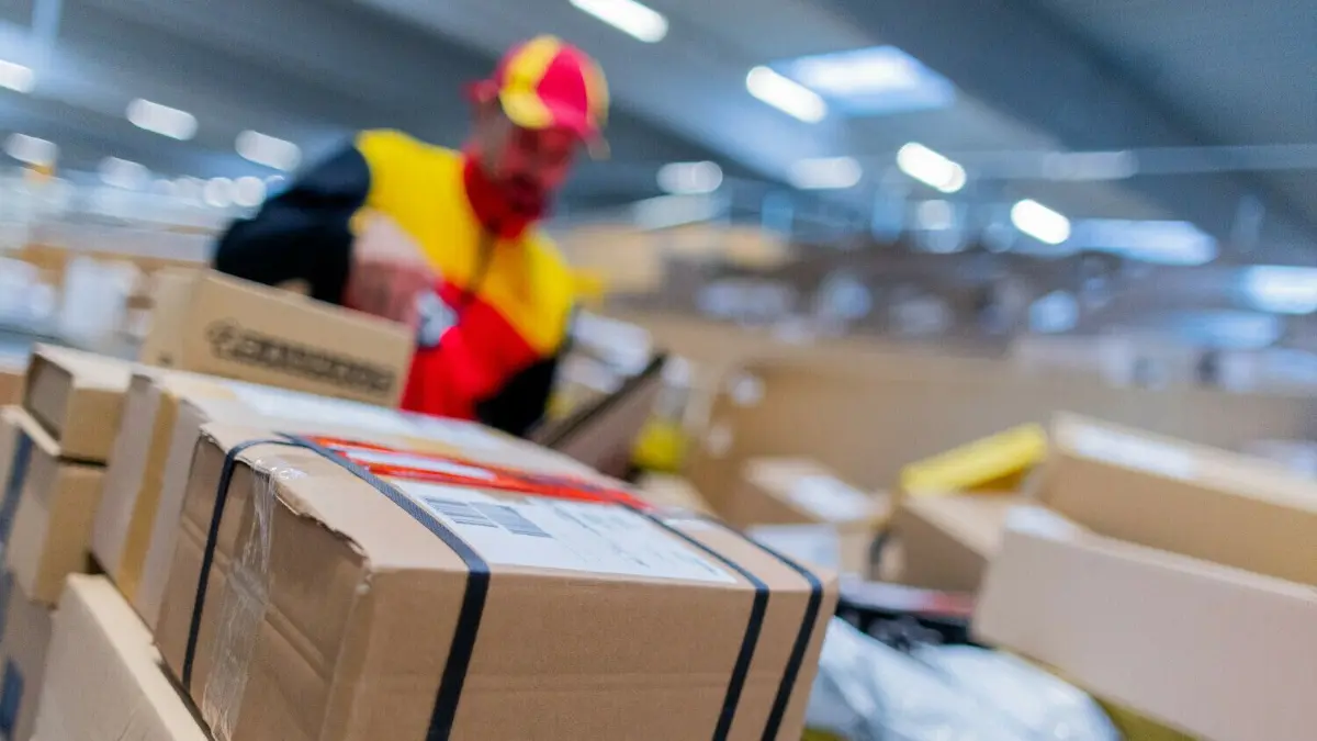 Ein DHL–Paketzusteller sortiert Pakete. Bis wann müssen Pakete und Briefe abgegeben werden, damit sie rechtzeitig an Weihnachten ankommen?
19.10.2022, Nordrhein-Westfalen, Köln: Ein Paketzusteller sortiert und räumt in einer Zustellbasis von Deutsche Post DHL Pakete in ein Zustellfahrzeug. Im diesjährigen Weihnachtsgeschäft rechnet die Deutsche Post DHL wieder mit Paketmassen. Foto: Rolf Vennenbernd/dpa +++ dpa-Bildfunk +++