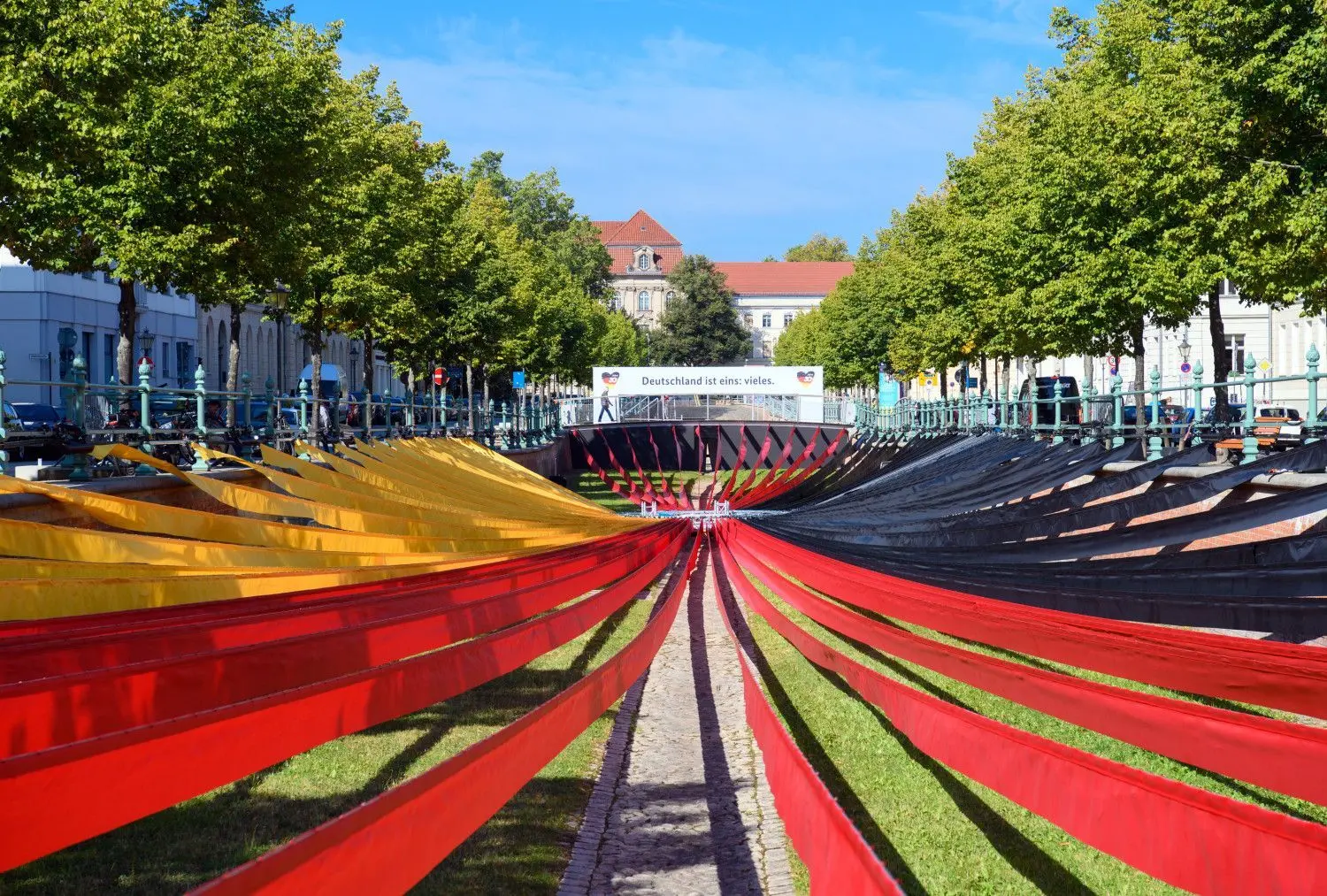 Schwarze, rote und gelbe Stoffbahnen der Ausstellung „Weg zur Einheit“ sind während eines Presserundgangs auf der EinheitsEXPO im Alten Stadtkanal aufgehängt.