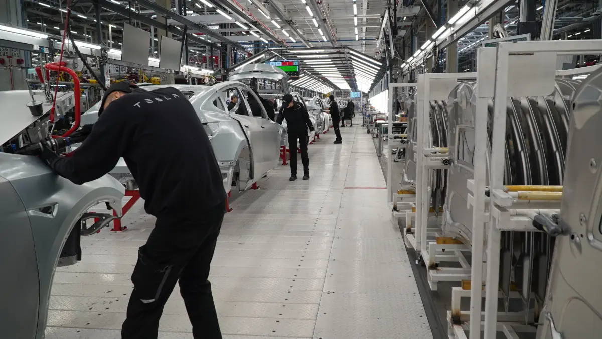 Tesla Fabrikbesuch: Einblick Gigafactory Grünheide: Die Feinheiten an der Karosserie werden von Tesla-Mitarbeitern am Fließband erledigt.