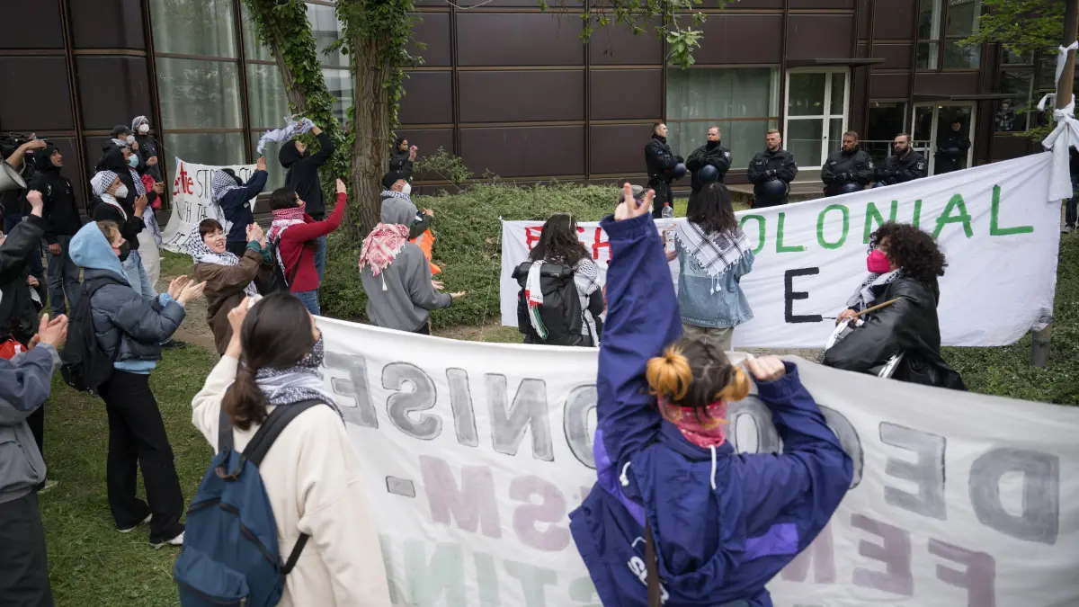 Teilnehmer stehen während einer pro-palästinensischen Demonstration der Gruppe «Student Coalition Berlin» auf dem Theaterhof der Freien Universität Berlin. Die Teilnehmer haben am Dienstagvormittag den Platz mit Zelten besetzt. +++ dpa-Bildfunk +++