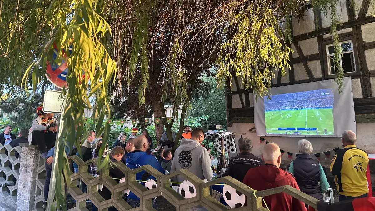 Anfeuern unter der Weide: Gemeinsam jubeln die EM-Fußballfans vor der Kulisse der alten Schlossmühle in Lauchhammer West mit.
