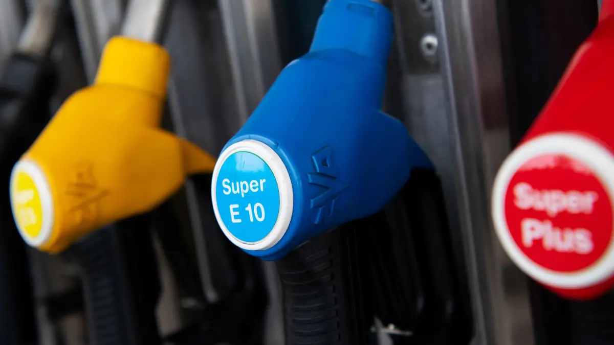 Zapfpistolen für verschiedene Kraftstoffarten, darunter auch E10, hängen an einer Zapfsäule an einer Tankstelle.