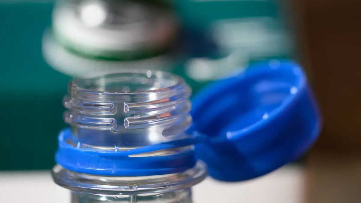 PRODUKTION - 26.06.2024, Sachsen, Dresden: Ein Saftkarton und eine Wasserflasche mit geöffneten Deckeln stehen auf einem Tisch. Um den Müll in der Landschaft zu verringern, sind vom 3. Juli 2024 an lose Verschlusskappen bei bestimmten Getränken verboten. Das betrifft Einwegverpackungen, die ganz oder teilweise aus Kunststoff bestehen · etwa Saftkartons oder Einweg-PET-Flaschen · mit einem Volumen bis zu drei Litern. (zu dpa: «Angebundene Kappen bei Flaschen seit heute Pflicht») Foto: Robert Michael/dpa +++ dpa-Bildfunk +++