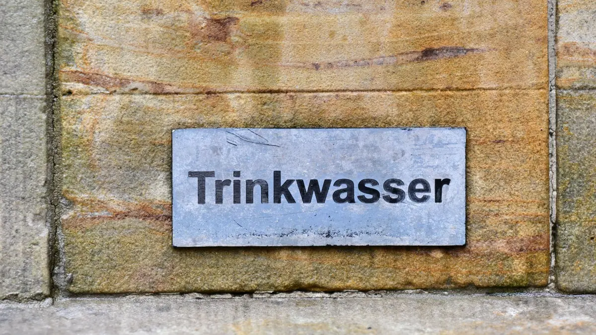 ARCHIV - 27.07.2023, Thüringen, Erfurt: «Trinkwasser» steht auf einem Schild an einem Trinkbrunnen (zu dpa: «Hitze: Städte bieten Obdachlosen zahlreiche Hilfen an») Foto: Martin Schutt/dpa +++ dpa-Bildfunk +++