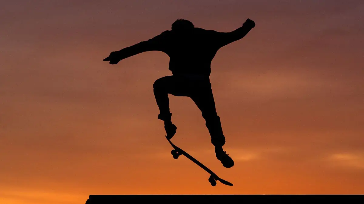 Ein Skater im Sonnenuntergang: ARCHIV - Wer sicher auf dem Skateboard rollen kann, kann sich an ersten Tricks probieren. (zu dpa: «3 Olympia-Sportarten ausprobiert: Tipps für Anfänger») Foto: Sebastian Gollnow/dpa/dpa-tmn - Honorarfrei nur für Bezieher des dpa-Themendienstes +++ dpa-Themendienst +++