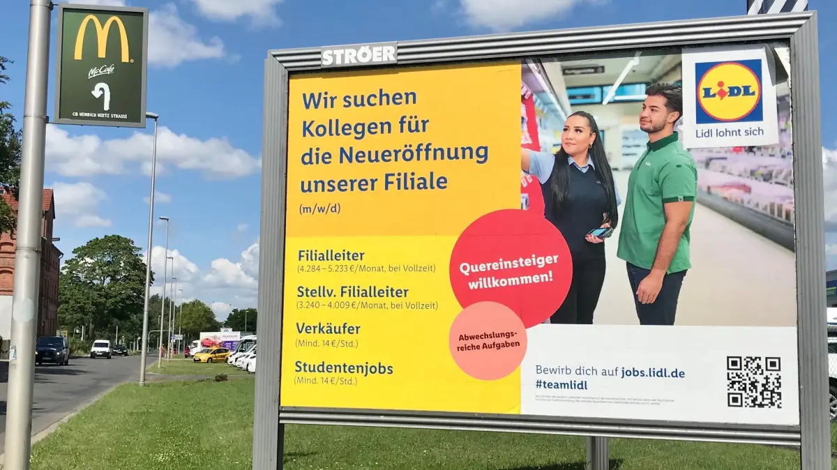 Auf großen Plakaten, wie hier kurz vor der Einfahrt zur Aldi-Filiale in Cottbus-Sielow sucht Lidl neue Mitarbeiter.