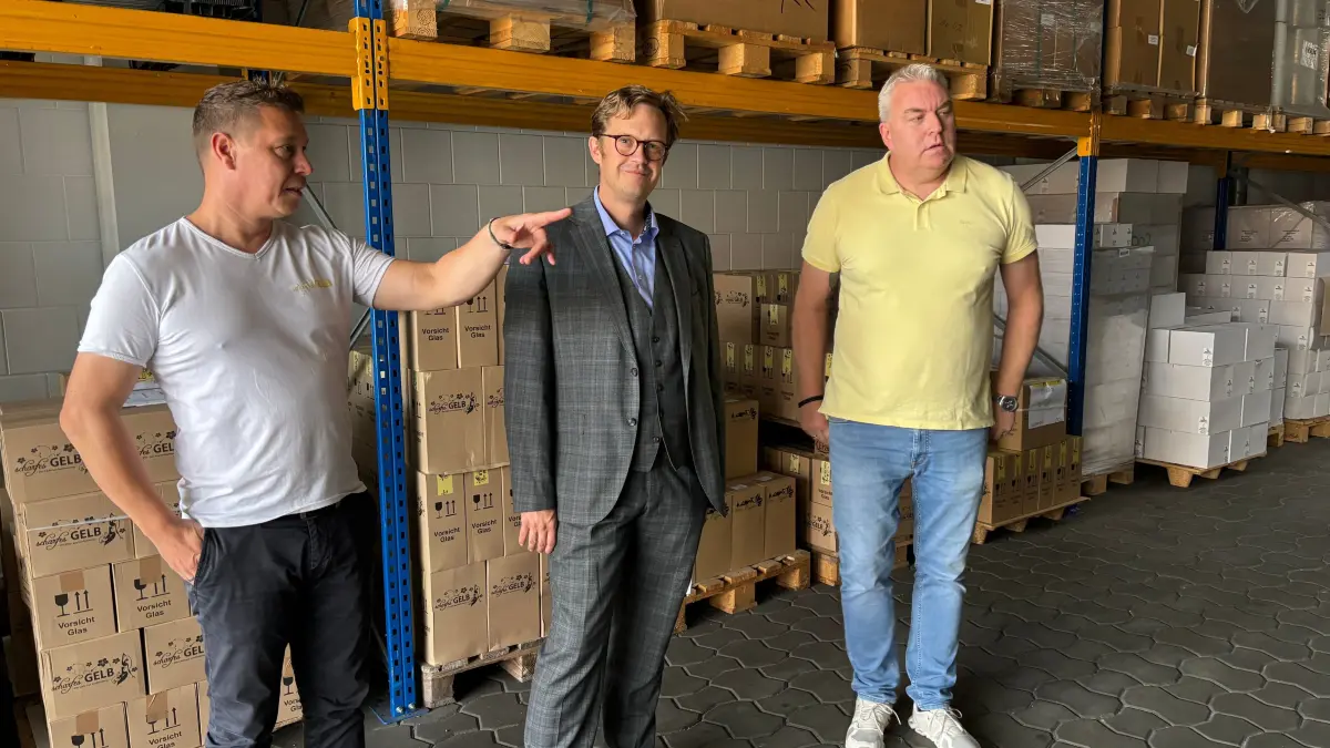 Das Hauptlager von Senftenbergs Eierlikörproduzenten ist bis unters Dach mit Kartonagen, Flaschen, Rohware und Etiketten gefüllt. Mit einem Hallen-Neubau soll Platz geschaffen werden. Im Bild: die beiden Geschäftsführer Heiko Tänzer und Danilo Trasper mit Bürgermeister Andreas Pfeiffer (Mitte).
