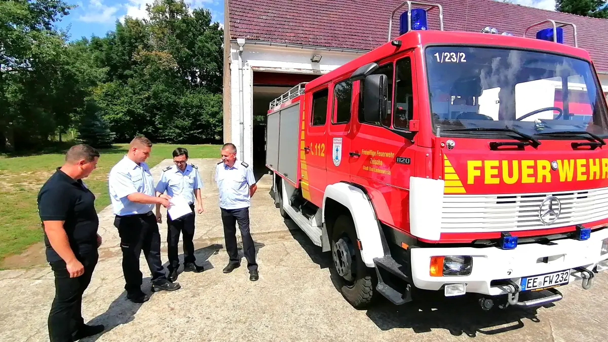 Das Gerätehaus der Freiwilligen Feuerwehr Zeischa wird erweitert, umgebaut und modernisiert. Dies erläutert hier Martin Neumann, stellvertretender Verbandsgemeindewehrführer Liebenwerda (2. v. l.). Außerdem im Bild: Ortswehrführer Kevin Müller (l.), Verbandsgemeindewehrführer Mathias Bauer (2. v. r.) und Kreisbrandmeister Steffen Ludewig.