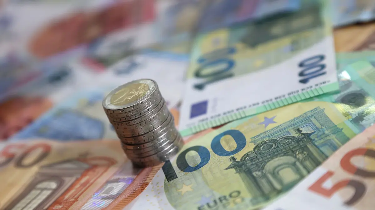 Fast jede zweite Gemeinde hat die Grundsteuer B erhöht: ILLUSTRATION - 15.05.2024, Bayern, Kaufbeuren: Ein Stapel mit Zwei-Euro-Münzen steht auf verschiedenen Euro-Banknoten. Eigentümer müssen sich nach Überzeugung des Bundes der Steuerzahler auf höhere Grundsteuern einstellen. (zu dpa: «Fast jede zweite NRW-Gemeinde hat die Grundsteuer B erhöht») Foto: Karl-Josef Hildenbrand/dpa +++ dpa-Bildfunk +++