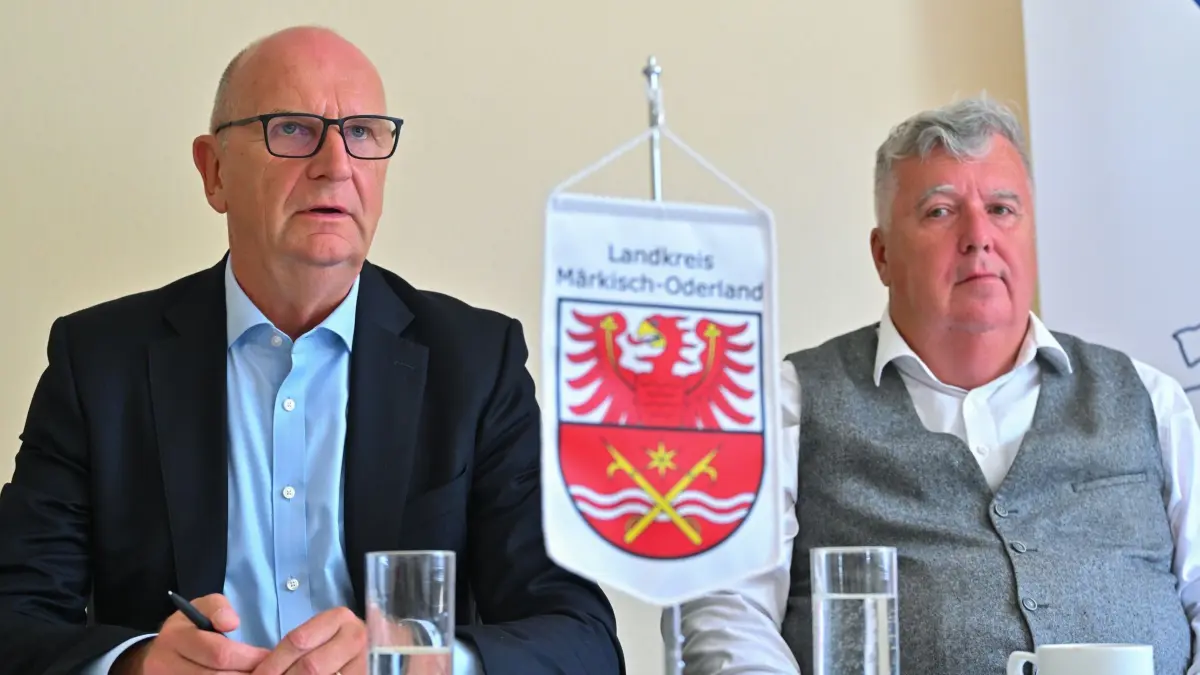 Pressekonferenz zur Bezahlkarte für Asylbewerber: 31.07.2024, Brandenburg, Vierlinden: Dietmar Woidke (l, SPD), Ministerpräsident von Brandenburg, und Gernot Schmidt (SPD), Landrat des Kreises Märkisch-Oderland, sprechen auf einer Pressekonferenz zu den Erfahrungen nach den ersten drei Monaten nach Einführung der Bezahlkarte für Asylbewerber in einer Außenstelle vom Sozialamt im Landkreis Märkisch-Oderland. Asylbewerber bekommen seit drei Monaten einen Teil der staatlichen Leistungen zum Lebensunterhalt nicht mehr als Bargeld oder als Scheck, sondern als Guthaben via Bezahlkarte. Nur ein geringerer Teil kann als Bargeld - als eine Art Taschengeld - abgehoben werden. Foto: Patrick Pleul/dpa +++ dpa-Bildfunk +++