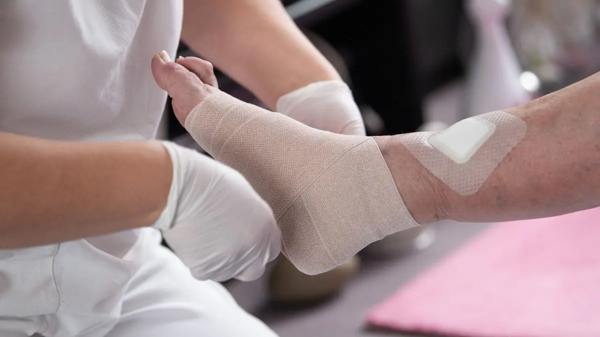 Pflege: ARCHIV - 10.05.2021, Hessen, Karben: Eine Pflegefachkraft legt in der ambulanten Pflege einen Kompressionsverband an. (zu dpa: «U-Haft wegen mutmaßlichen Betrugs bei Pflegedienst») Foto: Sebastian Gollnow/dpa +++ dpa-Bildfunk +++