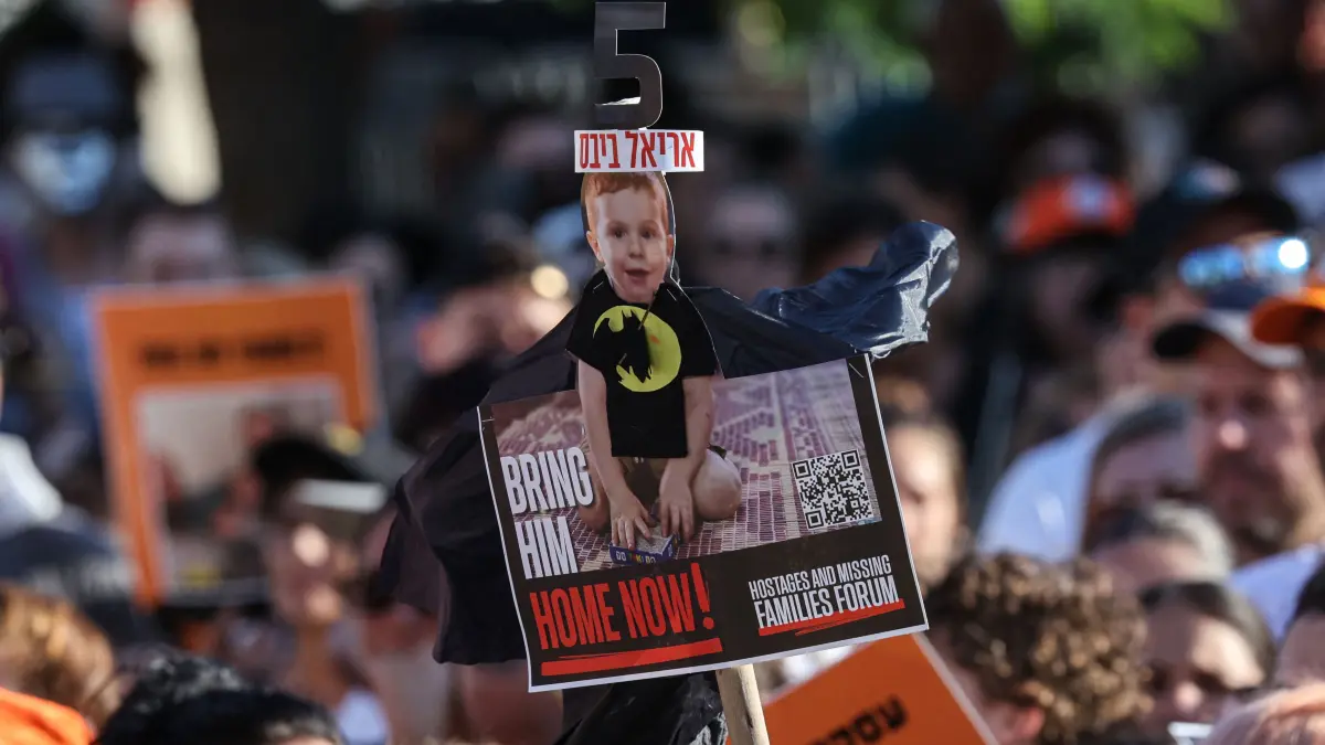 Participants lift placards and pictures during a gathering in Tel Aviv on August 5, 2024 to mark the fifth birthday of Ariel Bibas, held hostage in Gaza, and to call for the liberation of him and his family. Ariel, his baby brother Kfir, who would now be one year old, were kidnapped along with their parents Yarden and Shiri from their homes in Nir Oz kibbutz community near Gaza on October 7 when Hamas militants attacked southern Israel. (Photo by GIL COHEN-MAGEN / AFP)