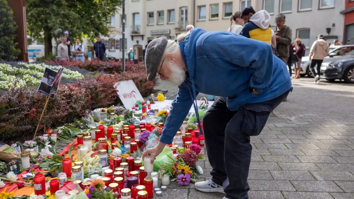 Nach der Messerattacke auf dem Solinger Stadtfest: 25.08.2024, Nordrhein-Westfalen, Solingen: Philipp Müller, Hauptorganisator der Jubiläums-Feier von Solingen, stellt im Gedenken an die Opfer eine Kerze auf. Bei einer Attacke auf der 650-Jahr-Feier der Stadt Solingen hat es Todesopfer und Verletzte gegeben. Foto: Thomas Banneyer/dpa +++ dpa-Bildfunk +++