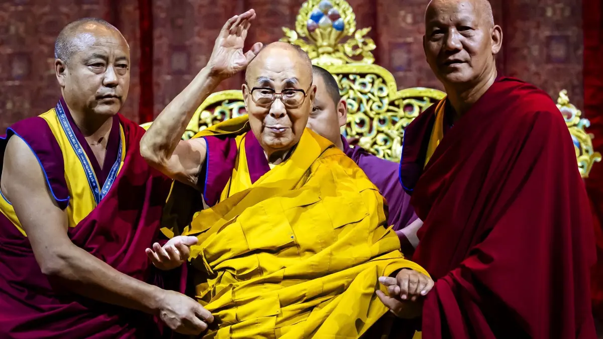 Der Dalai Lama in der Schweiz: 25.08.2024, Schweiz, Zürich: Das geistige Oberhaupt Tibets, der Dalai Lama, Tenzin Gyatso (M), wird von tibetischen Mönchen unterstützt, als er zu einem öffentlichen Vortrag im Hallenstadion in Zürich ankommt. Foto: Michael Buholzer/KEYSTONE/dpa +++ dpa-Bildfunk +++