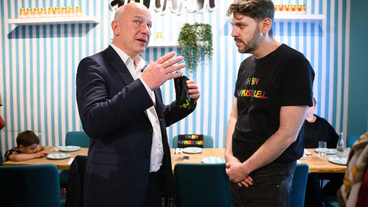 Kai Wegner (l, CDU), Regierender Bürgermeister von Berlin, besuchte im Juli 2024 das israelisch-palästinensische Restaurant „Kanaan“ und unterhält sich dort mit dem Besitzer des Lokals, Oz Ben David. Nach einem Einbruch in das Restaurant in Prenzlauer Berg war das Lokal von Unbekannten verwüstet worden.