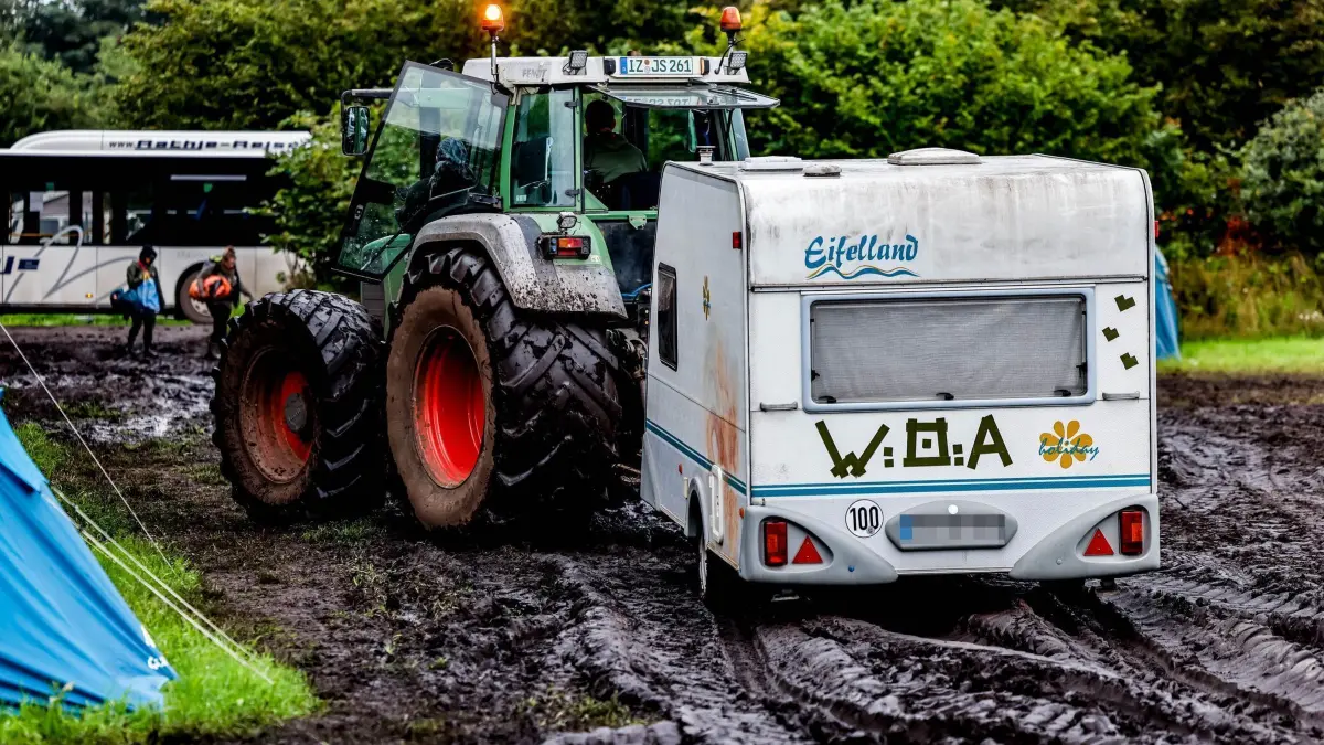 Wacken Open Air: ARCHIV - 06.08.2023, Schleswig-Holstein, Wacken: Ein Traktor zieht einen Wohnwagen vom verschlammten Campinggelände des Wacken Open Air. (zu dpa: «Wacken-Veranstalter: «Der Schlamm ist immer wieder anders»») Foto: Axel Heimken/dpa +++ dpa-Bildfunk +++