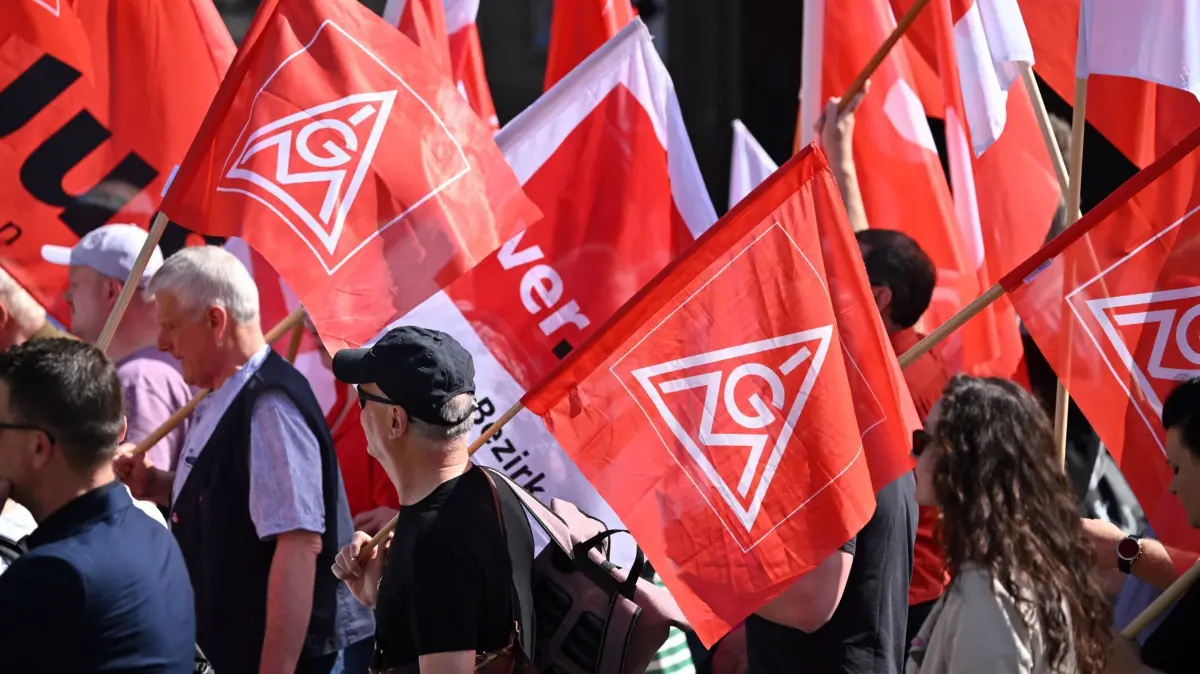 Gewerkschaften: ARCHIV - 01.05.2024, Thüringen, Erfurt: Teilnehmende einer Demonstration der IG Metall und des DGB Hessen-Thüringen zum Tag der Arbeit laufen mit Fahnen durch die Erfurter Altstadt. (zu dpa: «Gewerkschaften werben mit Pommes für mehr Tarifbindung») Foto: Martin Schutt/dpa +++ dpa-Bildfunk +++