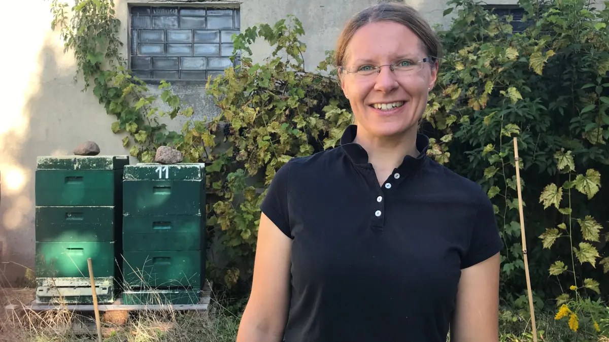 Pfarrerin Ulrike Garve im Pfarrgarten in Lübbenau. Im Hintergrund sieht man ein Hobby von ihr: Bienen!