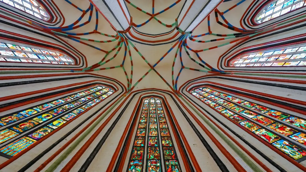 Die gläserne Bilderbibel von St. Marien: ARCHIV - 19.06.2024, Brandenburg, Frankfurt (Oder): Licht fällt durch die bunten Scheiben der historischen Bleiglasfenster in der Marienkirche. Seit dem Jahr 2009 können Besucher der Marienkirche die gläserne Bilderbibel wieder betrachten. Die mittleren drei hohen Fenster, mit insgesamt 117 farbenfrohe Fensterscheiben, sind im Zweiten Weltkrieg als Beutekunst in die Sowjetunion gelangt und wurden erst im Jahr 2002 und 2008 von Russland zurückgegeben. (zu dpa: «Auszeichnung für Schweizerhaus Seelow und Kirchenkonzerte») Foto: Patrick Pleul/dpa +++ dpa-Bildfunk +++