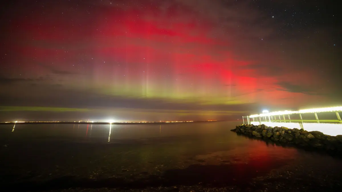 Polarlichter leuchten über der Lübecker Bucht,rechts im Bild ist die Seebrücke Niendorf zu sehen. Nach Angaben des amerikanischen Atmosphärendienstes NOAA gab es in der Nacht einen leichten Sonnensturm. Vorhergesagt waren Polarlichter bereits für Anfang des Wochenendes. +++ dpa-Bildfunk +++