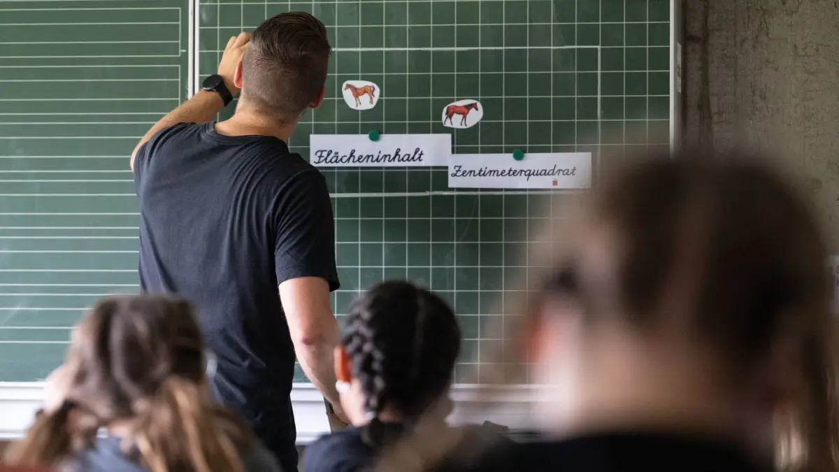 Unterricht an der Grundschule: ARCHIV - 27.06.2024, Baden-Württemberg, Neckartailfingen: Ein Lehrer macht im Unterricht einer vierten Klasse einer Grundschule einen Tafelanschrieb, während an der Tafel Zettel mit der Aufschrift «Flächeninhalt» und «Zentimeterquadrat» hängen. (zu dpa: «Umfrage: An vielen Schulen fällt Unterricht aus») Foto: Marijan Murat/dpa +++ dpa-Bildfunk +++