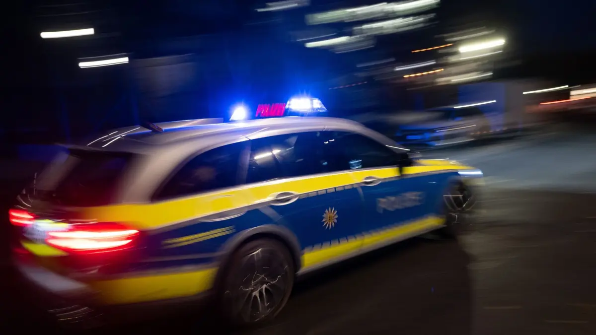 Illustration - Polizei: ILLUSTRATION - 30.11.2023, Baden-Württemberg, Stuttgart: Ein Polizeifahrzeug fährt im Rahmen eines Fototermins mit Blaulicht an einem Gebäude vorbei (gestellte Szene, Langzeitblichtung mit Wischeffekt). (zu dpa: «Polizei verfolgt 19 Jahre alten Raser») Foto: Marijan Murat/dpa +++ dpa-Bildfunk +++