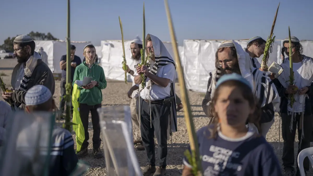 21.10.2024, Israel, Be'eri: Israelische rechtsextreme Aktivisten beten während einer Veranstaltung im Rahmen des Laubhüttenfestes oder Sukkot-Festes in der Nähe der Grenze zum Gazastreifen. Radikale Siedler und Mitglieder des israelischen Parlaments haben sich zu der Veranstaltung unter dem Motto «Rückkehr nach Gaza» getroffen. Foto: Ilia Yefimovich/dpa +++ dpa-Bildfunk +++