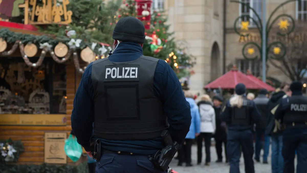 13.12.2018, Sachsen, Dresden: Polizisten gehen über den Dresdner Striezelmarkt. Nach dem Anschlag in Dresdens Partnerstadt Straßburg halten die Behörden den Schutz auf Sachsens Weihnachtsmärkten für ausreichend. Foto: Sebastian Kahnert/dpa-Zentralbild/dpa +++ dpa-Bildfunk +++
