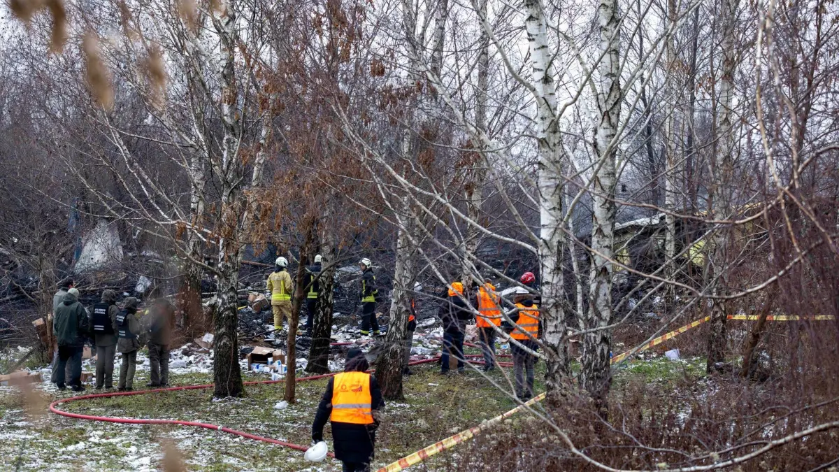 Frachtflugzeug aus Leipzig stürzt auf Wohngebäude in Litauen: 25.11.2024, Litauen, Vilnius: Mitarbeiter des litauischen Katastrophenschutzministeriums arbeiten in der Nähe der Stelle, an der ein DHL-Frachtflugzeug in ein Haus in der Nähe der litauischen Hauptstadt Vilnius, Litauen, gestürzt ist. Foto: Mindaugas Kulbis/AP +++ dpa-Bildfunk +++