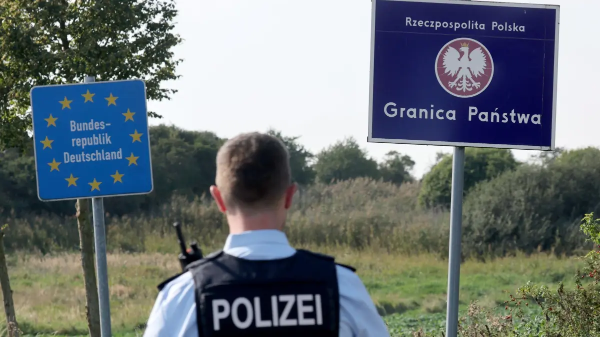 Unerlaubte Einreisen an deutsch-polnischer Grenze: ARCHIV - 28.09.2023, Mecklenburg-Vorpommern, Linken: Bei einer flexiblen Schwerpunktkontrolle unmittelbar an der deutsch-polnischen Grenze in der Nähe des ehemaligen Grenzübergang Linken steht ein Bundespolizist vor den Schildern für Deutschland und Polen. (zu dpa: «Bereits rund 2.200 unerlaubte Einreisen aus Polen nach MV») Foto: Bernd Wüstneck/dpa +++ dpa-Bildfunk +++