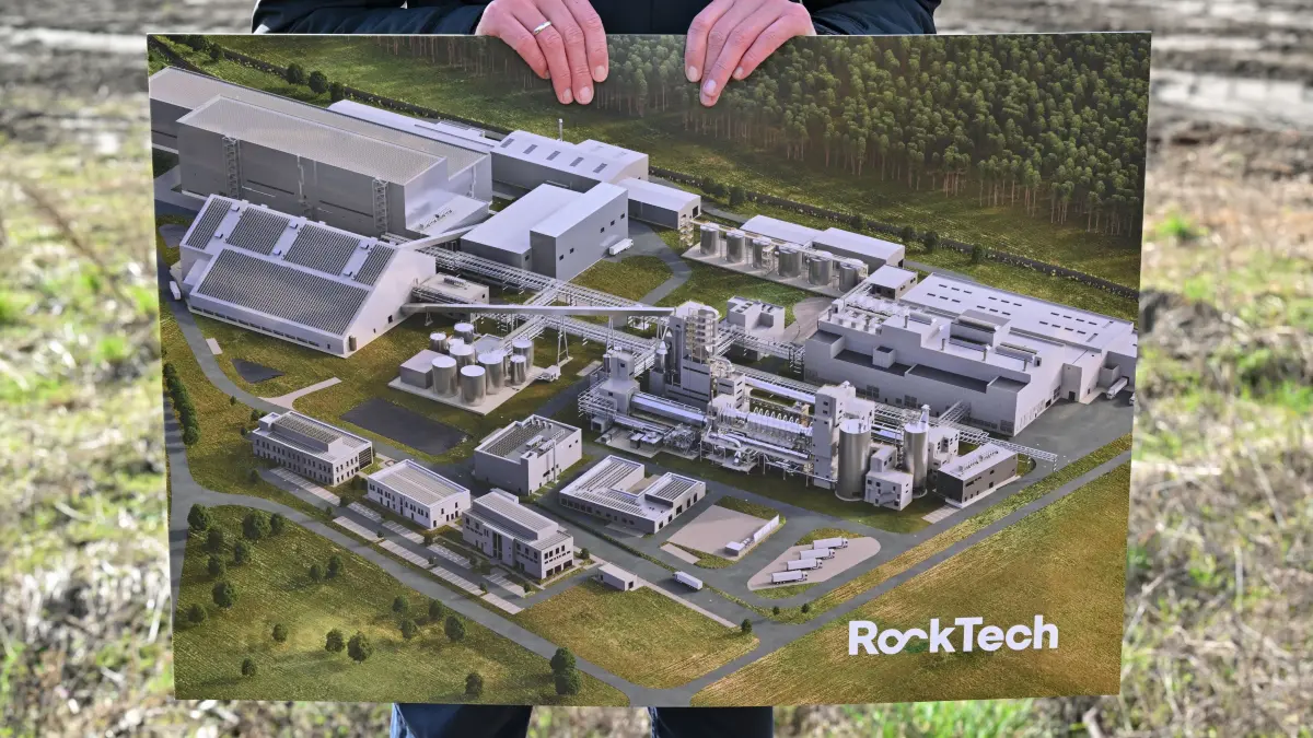 Ein Bild mit einer Computersimulation der fertigen Fabrik zeigt ein Mitarbeiter von Rock Tech auf dem Baugelände für eine Lithiumfabrik des kanadischen Unternehmens Rock Tech. Am selben Tag wurde mit einem symbolischen Spatenstich der Bau einer Lithiumfabrik des kanadischen Unternehmens Rock Tech begonnen. Dafür errichtet das Rohstoff-Unternehmen in der Stadt an der Neiße eine Konverteranlage. Sie dient der Herstellung von batteriefähigem Lithiumhydroxid für den Einsatz in der Elektromobilität. Jährlich sollen nach Angaben des Unternehmens 24 000 Tonnen Lithiumhydroxid für Batterien von 500 000 Elektroautos produziert werden. +++ dpa-Bildfunk +++